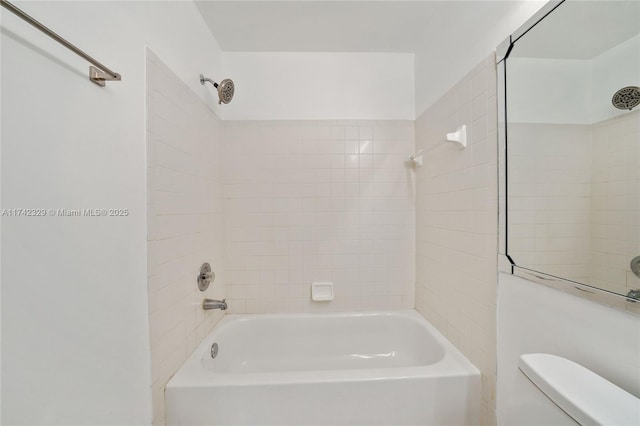 bathroom featuring toilet and tiled shower / bath combo