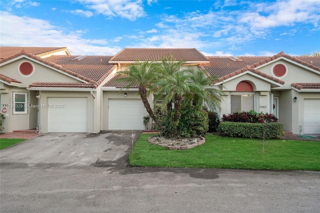 mediterranean / spanish house with a garage and a front yard