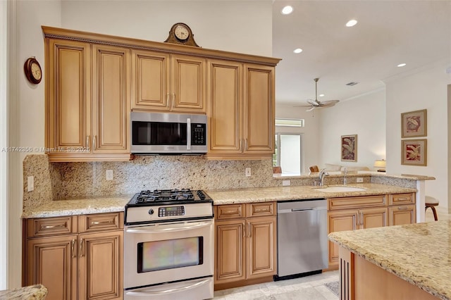 kitchen with a sink, light stone countertops, stainless steel appliances, backsplash, and recessed lighting