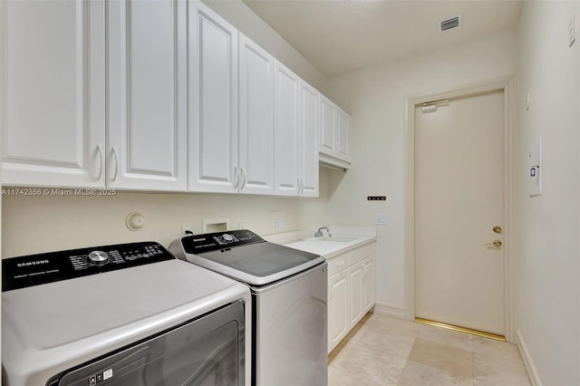 washroom featuring a sink, visible vents, baseboards, washer and dryer, and cabinet space