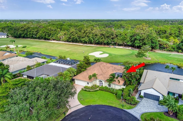 aerial view with a forest view, a water view, and golf course view