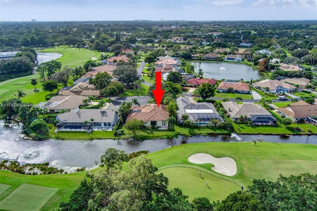 birds eye view of property with golf course view, a water view, and a residential view