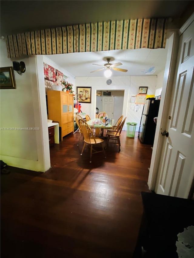 dining space with ceiling fan and dark hardwood / wood-style flooring