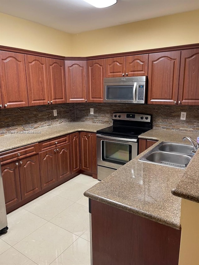 kitchen featuring tasteful backsplash, appliances with stainless steel finishes, sink, and dark stone counters