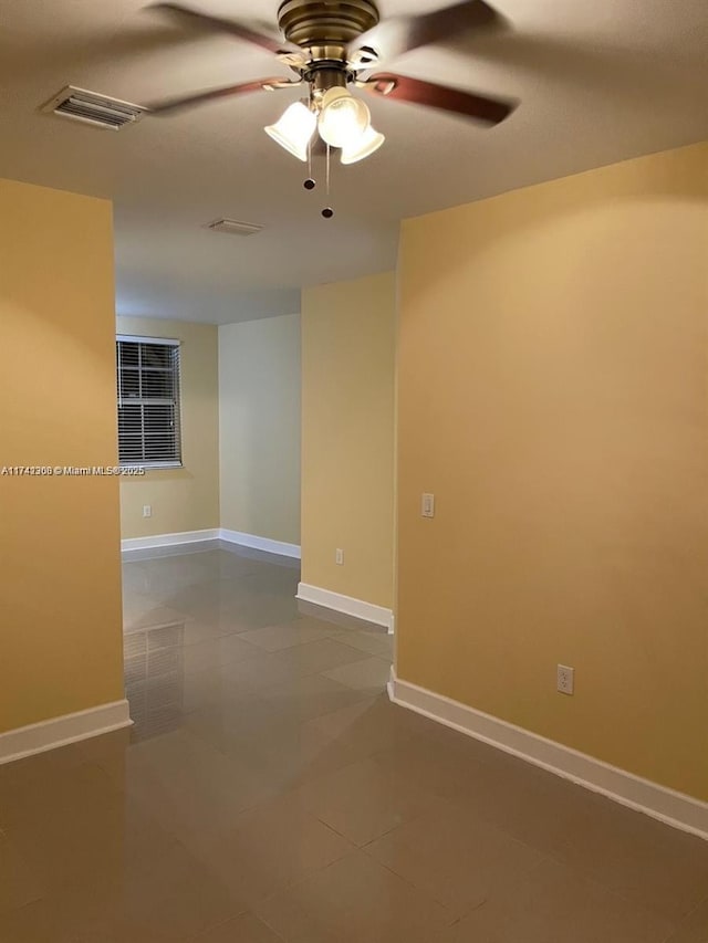 tiled spare room featuring ceiling fan