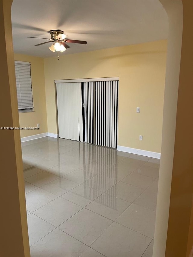 tiled empty room with ceiling fan