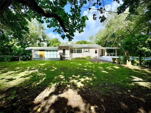 rear view of house featuring a patio and a yard