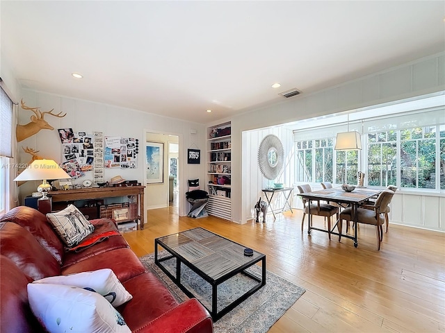 living area with built in features, light wood finished floors, visible vents, and recessed lighting