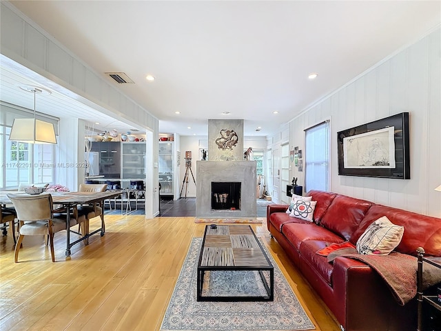 living room with ornamental molding, hardwood / wood-style floors, and a fireplace