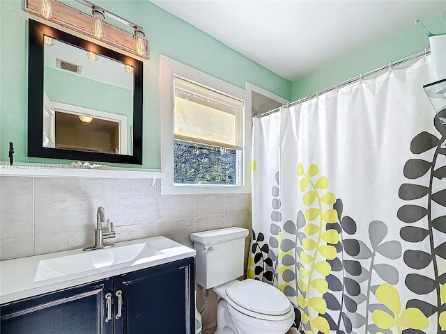 bathroom featuring vanity, tile walls, walk in shower, and toilet