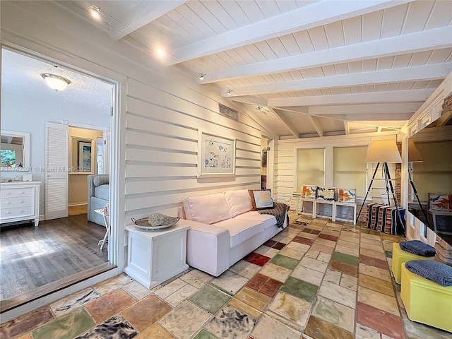 living room featuring wood ceiling, wood walls, and vaulted ceiling with beams