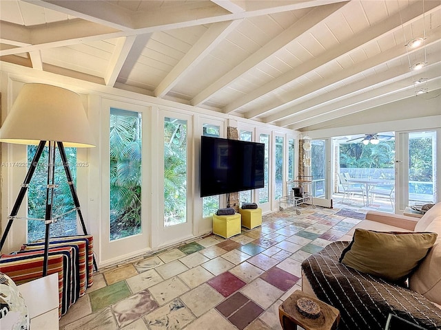 living area with ceiling fan, stone tile floors, and lofted ceiling with beams