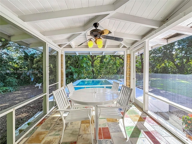 unfurnished sunroom featuring beamed ceiling, ceiling fan, and outdoor dining space
