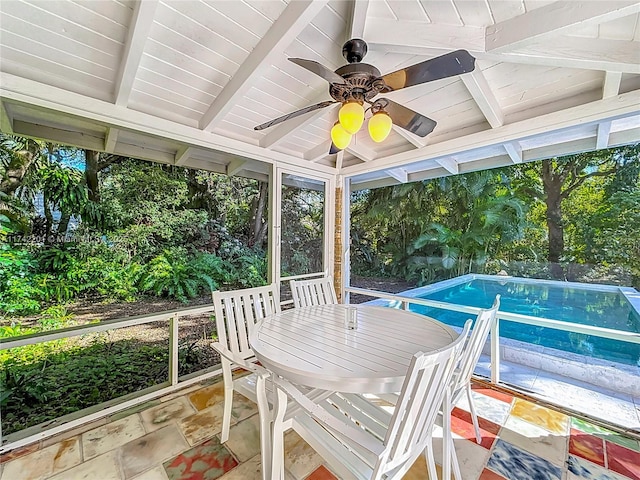 sunroom featuring beamed ceiling and ceiling fan