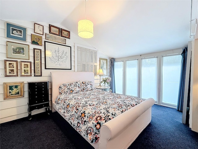 bedroom featuring access to outside, dark colored carpet, and lofted ceiling