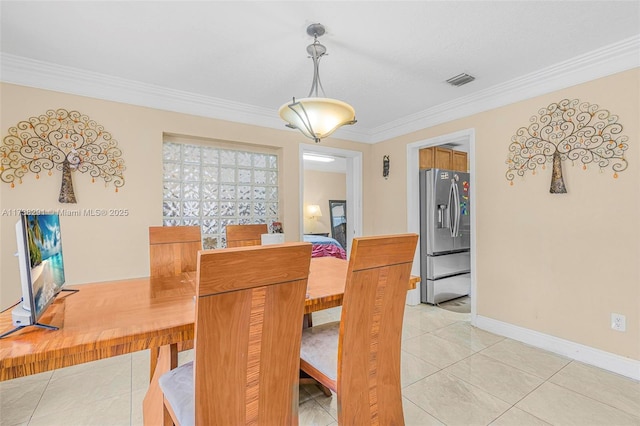 dining area with crown molding and light tile patterned floors