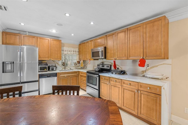 kitchen featuring sink, crown molding, light tile patterned floors, and appliances with stainless steel finishes