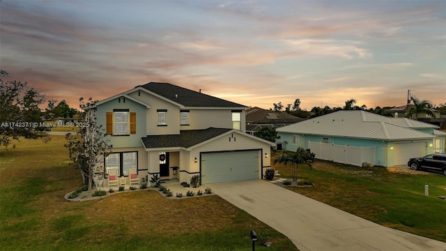 view of front of property featuring a garage and a lawn