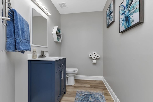 bathroom featuring vanity, toilet, and hardwood / wood-style floors