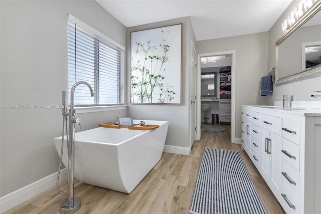 bathroom with hardwood / wood-style flooring, a bathing tub, and vanity