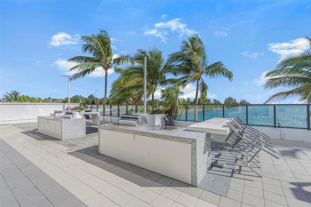 view of patio / terrace with a bar, a water view, and area for grilling