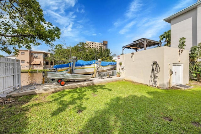 view of yard featuring a water view and a boat dock