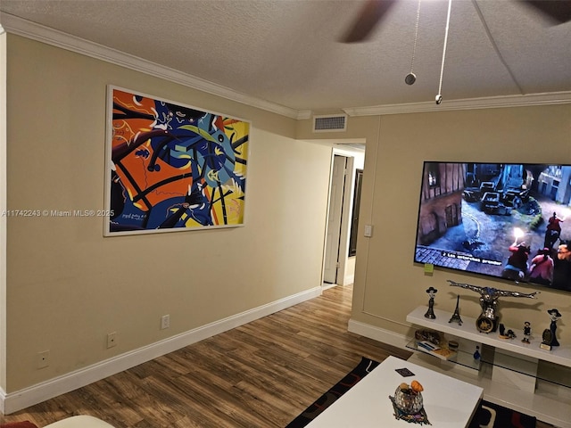 home theater with hardwood / wood-style flooring, ornamental molding, ceiling fan, and a textured ceiling