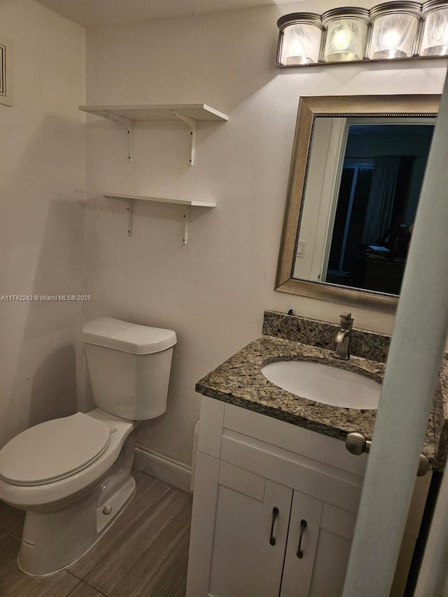 bathroom with vanity, wood-type flooring, and toilet