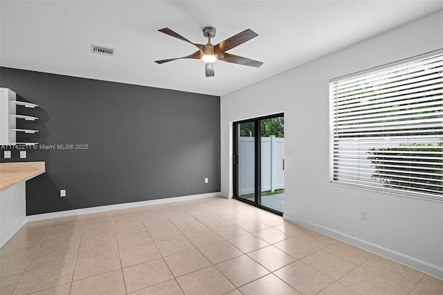 spare room with ceiling fan and light tile patterned floors