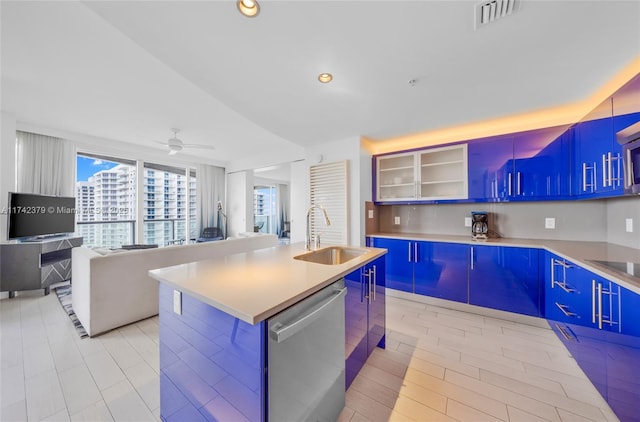 kitchen featuring blue cabinets, an island with sink, sink, stainless steel dishwasher, and ceiling fan