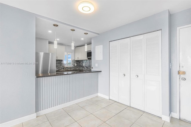 kitchen with white cabinetry, tasteful backsplash, hanging light fixtures, kitchen peninsula, and stainless steel appliances