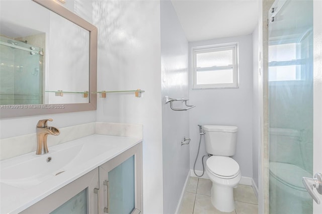 bathroom with tile patterned flooring, vanity, a shower with shower door, and toilet