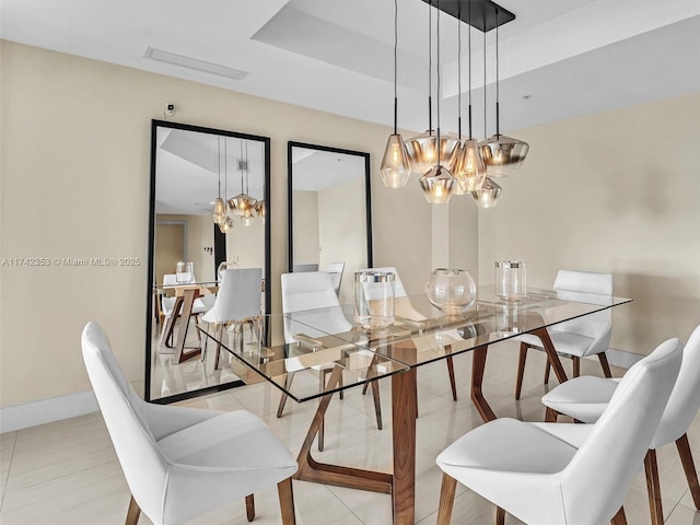 tiled dining room with a raised ceiling