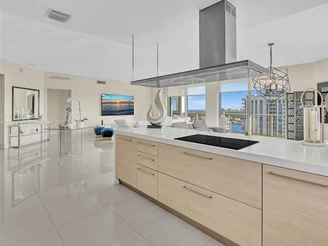 kitchen featuring black electric stovetop, light brown cabinets, hanging light fixtures, and island exhaust hood