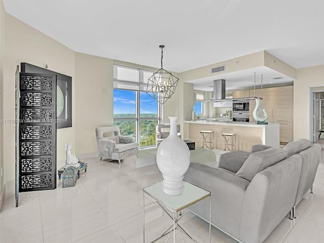 living room with light tile patterned floors and an inviting chandelier