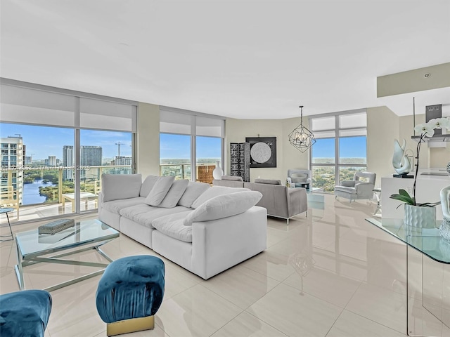 tiled living room with expansive windows, a water view, a healthy amount of sunlight, and a notable chandelier