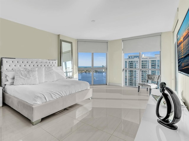 bedroom with floor to ceiling windows and light tile patterned flooring