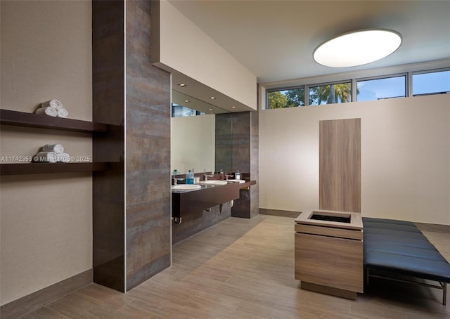 bathroom featuring hardwood / wood-style flooring, a healthy amount of sunlight, and dual sinks