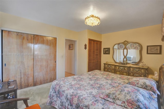 bedroom with light carpet and two closets