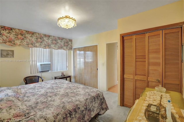 carpeted bedroom featuring multiple closets and cooling unit