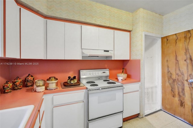 kitchen with electric stove, sink, and white cabinets