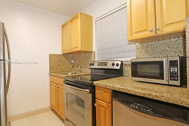 kitchen featuring stainless steel appliances, backsplash, and light stone counters