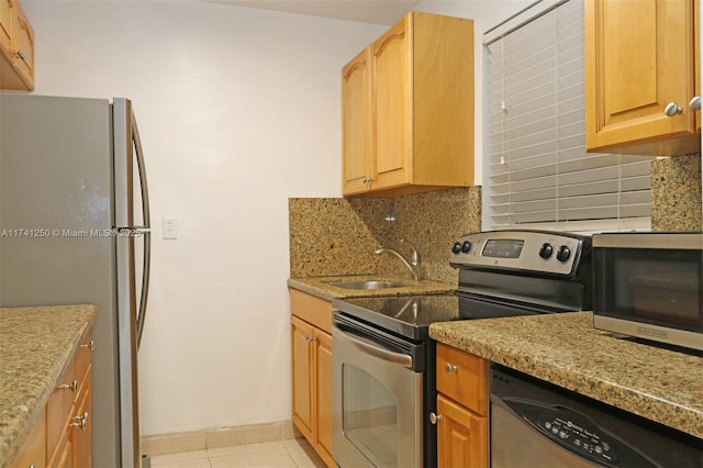 kitchen featuring tasteful backsplash, sink, light tile patterned floors, and stainless steel appliances