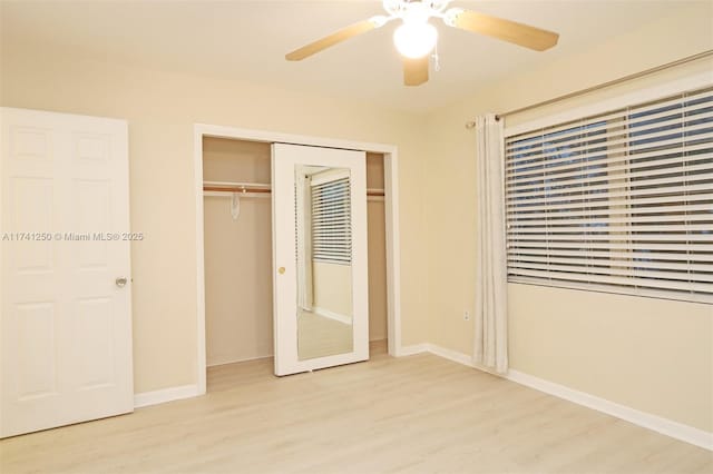 unfurnished bedroom with ceiling fan, light wood-type flooring, and a closet