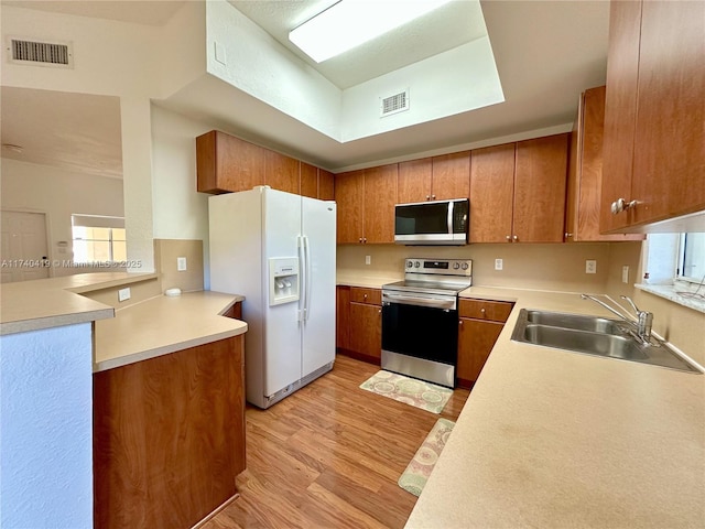 kitchen featuring a sink, visible vents, light wood finished floors, and stainless steel appliances