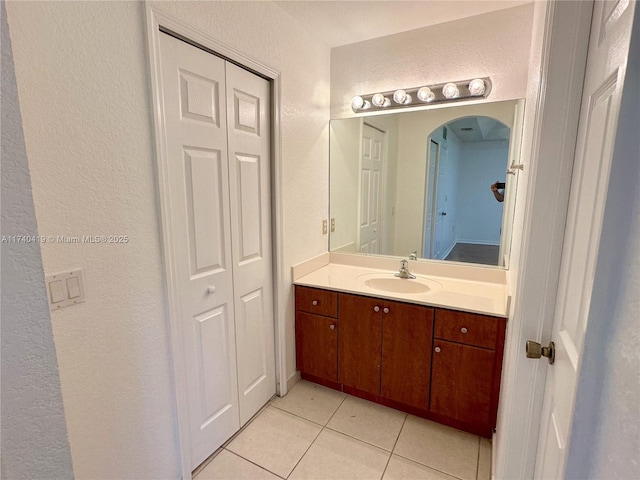 bathroom featuring a textured wall, tile patterned floors, and vanity