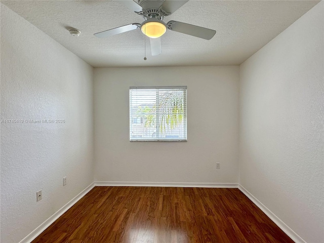 empty room featuring baseboards, ceiling fan, wood finished floors, and a textured ceiling