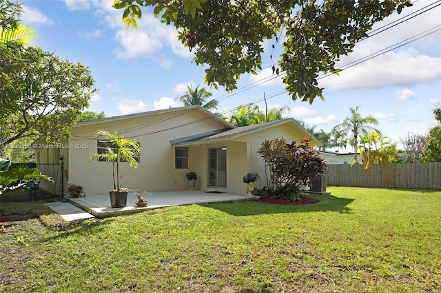 rear view of house with a patio area and a lawn