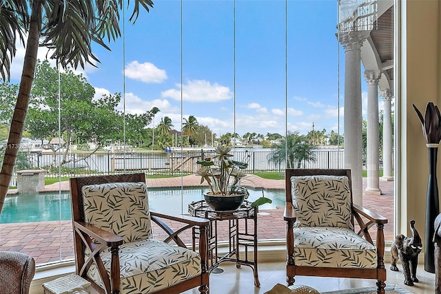 sunroom with plenty of natural light and a water view