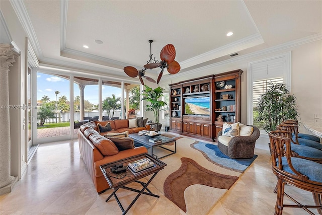 tiled living room featuring crown molding, ceiling fan, and a tray ceiling